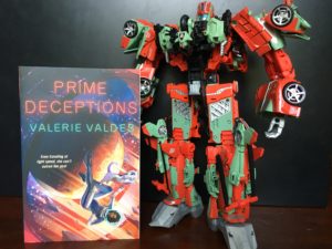 The book Prime Deceptions by Valerie Valdes next to the Victorion Transformers model